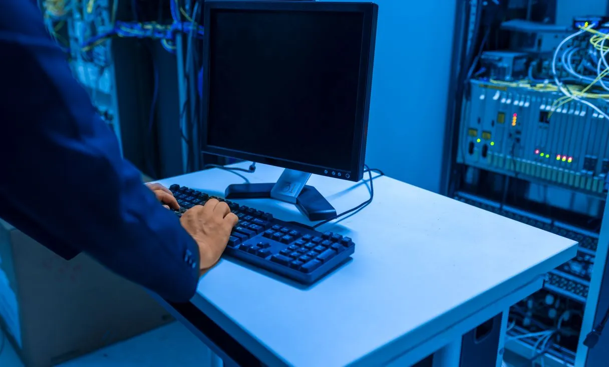 Técnico de TI em sala de servidores mexendo em equipamento de rede, representando: Servidor negou acesso ao arquivo? Veja por que isso acontece