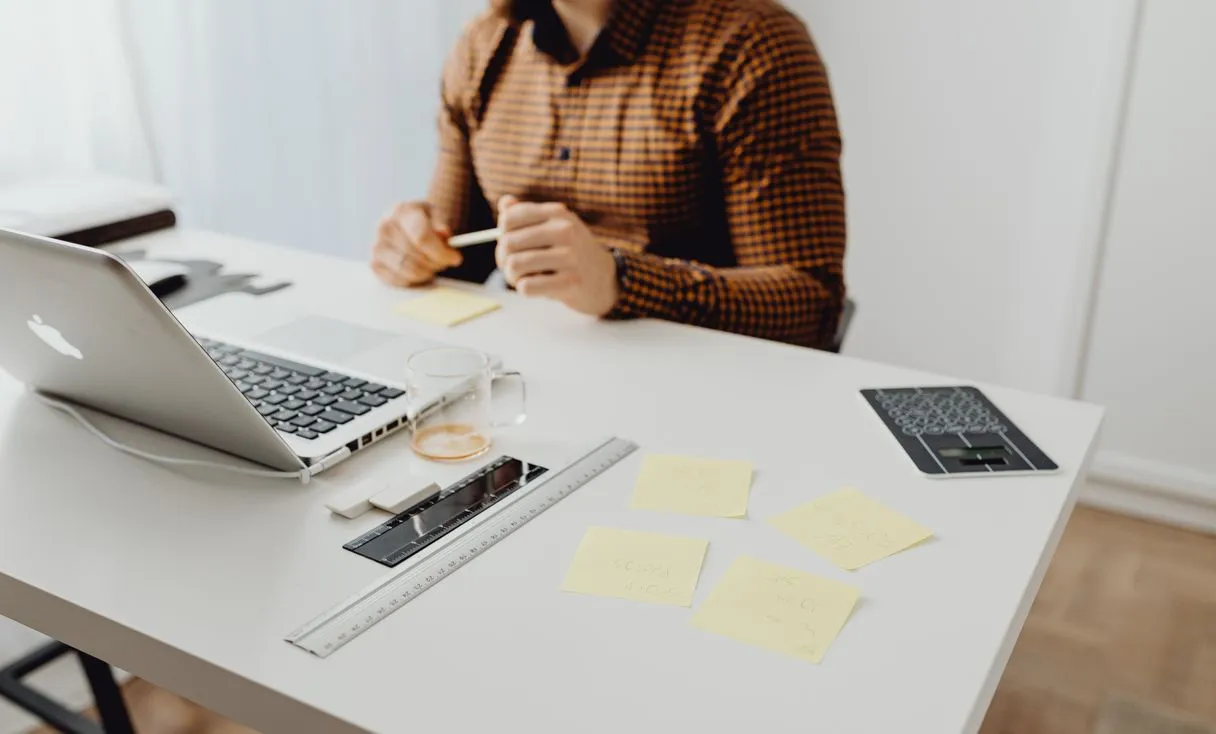 Mesa de trabalho com notebook e materiais de escritório representando: Onboarding de colaborador: acesso, e-mail e PC prontos