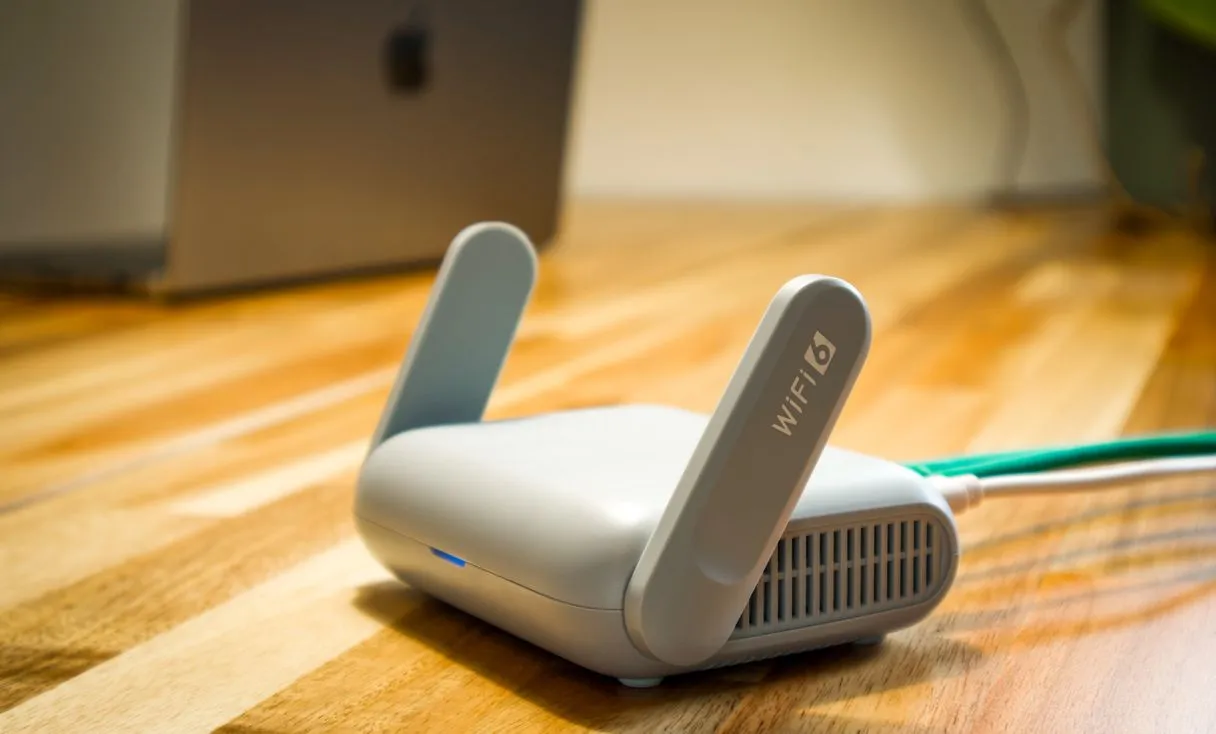 Roteador Wi‑Fi sobre a mesa representando: Roteador doméstico na empresa? Por que cai e como resolver