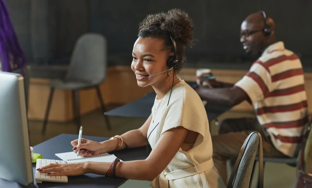 Atendente com headset em mesa de escritório representando: URA e filas no Teams: como parar ligação perdida e atender mais