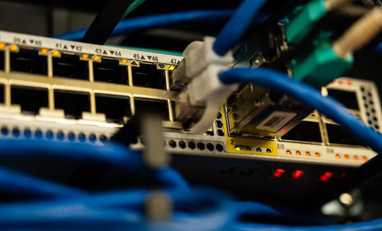 Close de switch com cabos de rede plugados representando: VPN instável na empresa? Como parar a queda do trabalho remoto